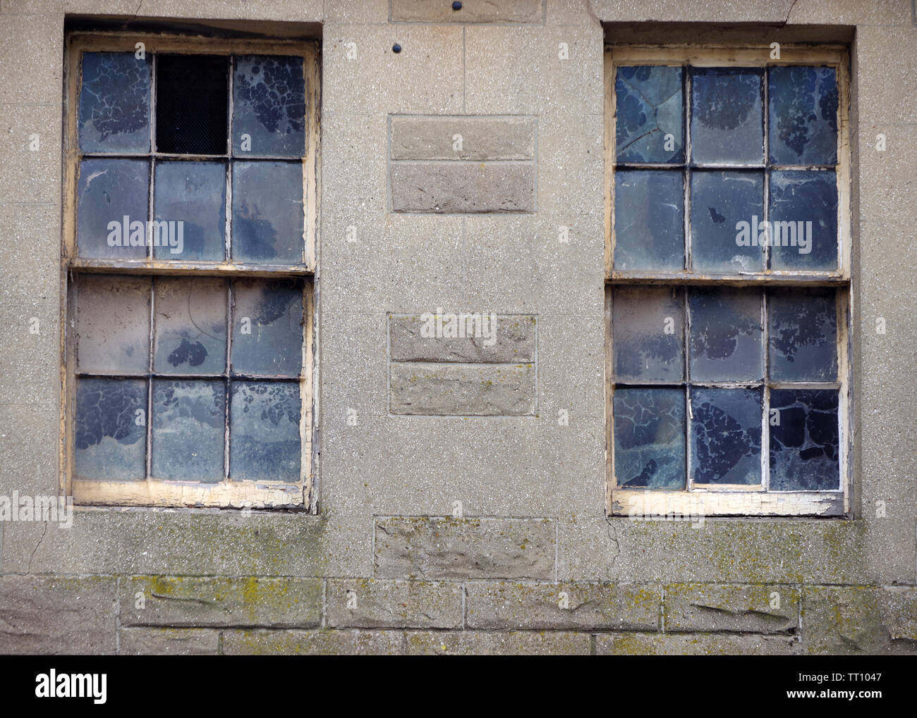 Sporche finestre a ghigliottina sopra un negozio di Dunbar High Street, East Lothian, Scozia Foto Stock