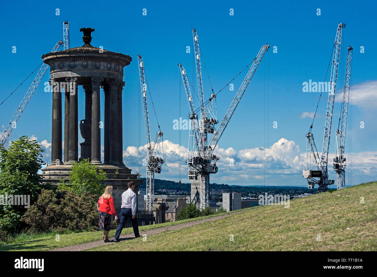 Un paio di piedi da Dugald Stewart monumento su Calton Hill, Edimburgo. Sullo sfondo sono le gru lavorano su St James progetto. Foto Stock