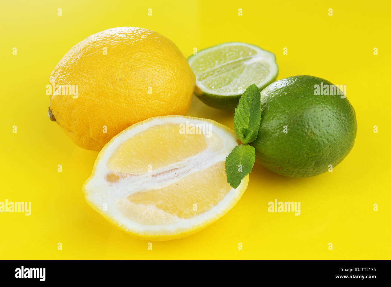 I Limoni e limette, su sfondo giallo Foto Stock