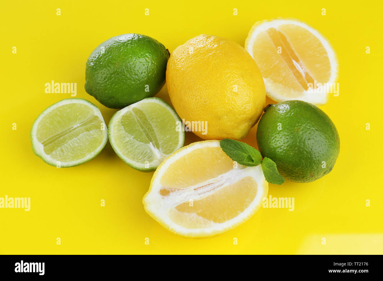 I Limoni e limette, su sfondo giallo Foto Stock