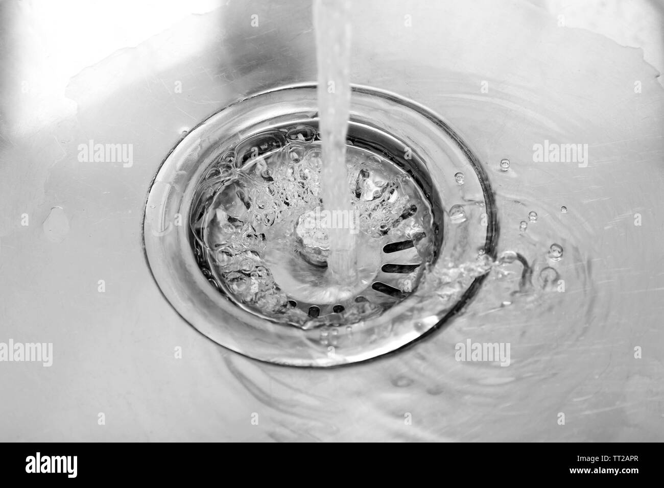 L'acqua che scorre verso il basso il foro nel lavello da cucina Foto Stock