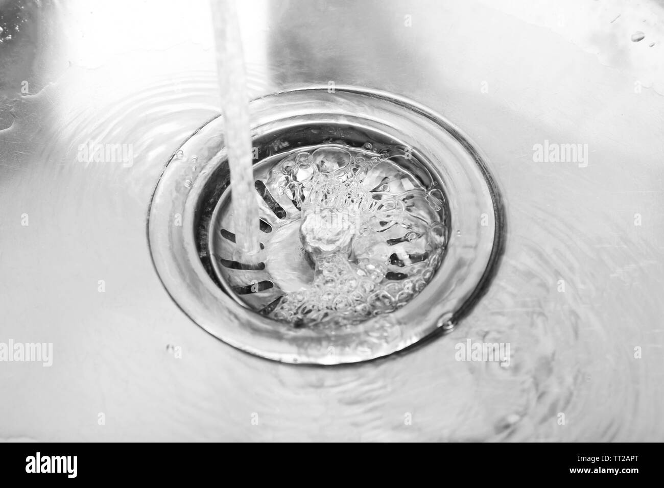 L'acqua che scorre verso il basso il foro nel lavello da cucina Foto Stock