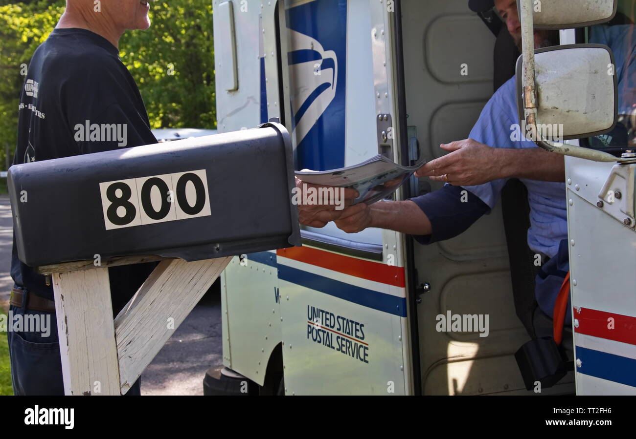Cromwell, CT / STATI UNITI D'America - 18 Maggio 2019: postino mani un uomo la sua mail Foto Stock