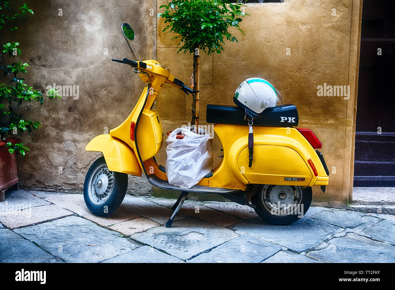 Vintage Sccooter con un piccolo albero parcheggiate lungo una casa, Pienza, Toscana, Italia Foto Stock