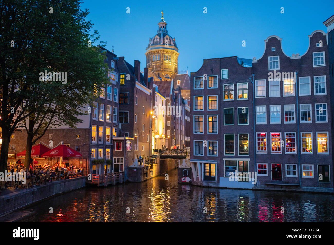 Scena notturna in Amsterdam con edifici illuminati e di un ristorante esterno, Paesi Bassi Foto Stock
