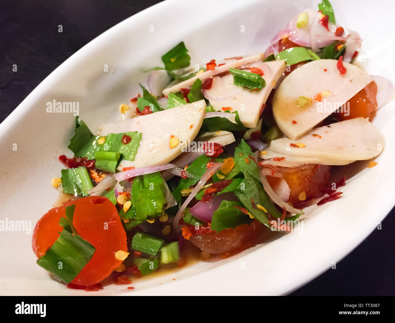 Piccante e aspro Thai insalata condita salate con tuorlo d'uovo, bianco insaccato di carne e verdure come la molla di cipolla, prezzemolo, peperoncino essiccato e cipolla Foto Stock