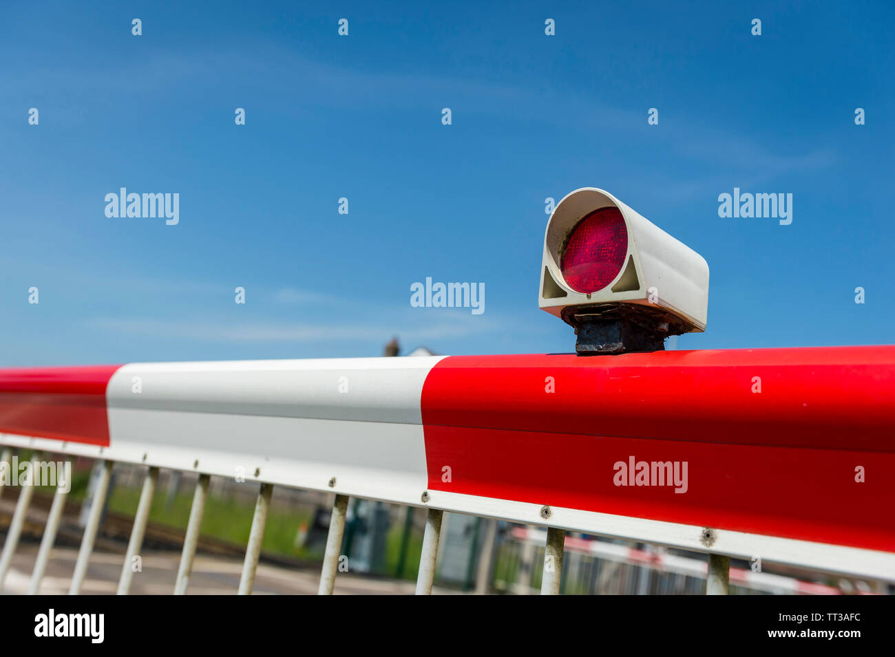 Barriere di sicurezza nella posizione di chiusura attraverso un passaggio a livello ferroviario nel Regno Unito. Foto Stock