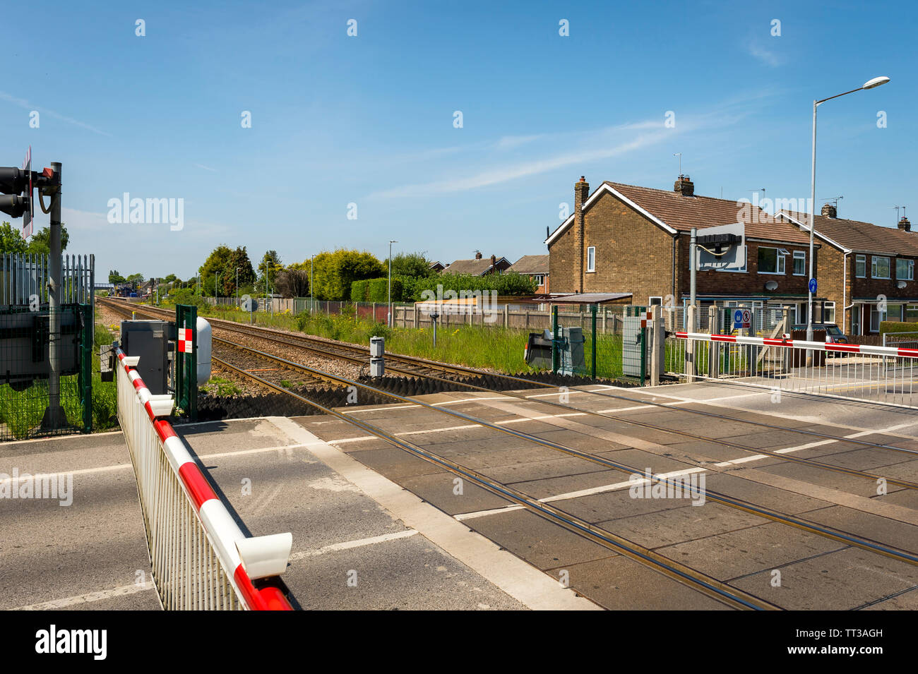 Barriere di sicurezza nella posizione di chiusura attraverso un passaggio a livello ferroviario nel Regno Unito. Foto Stock