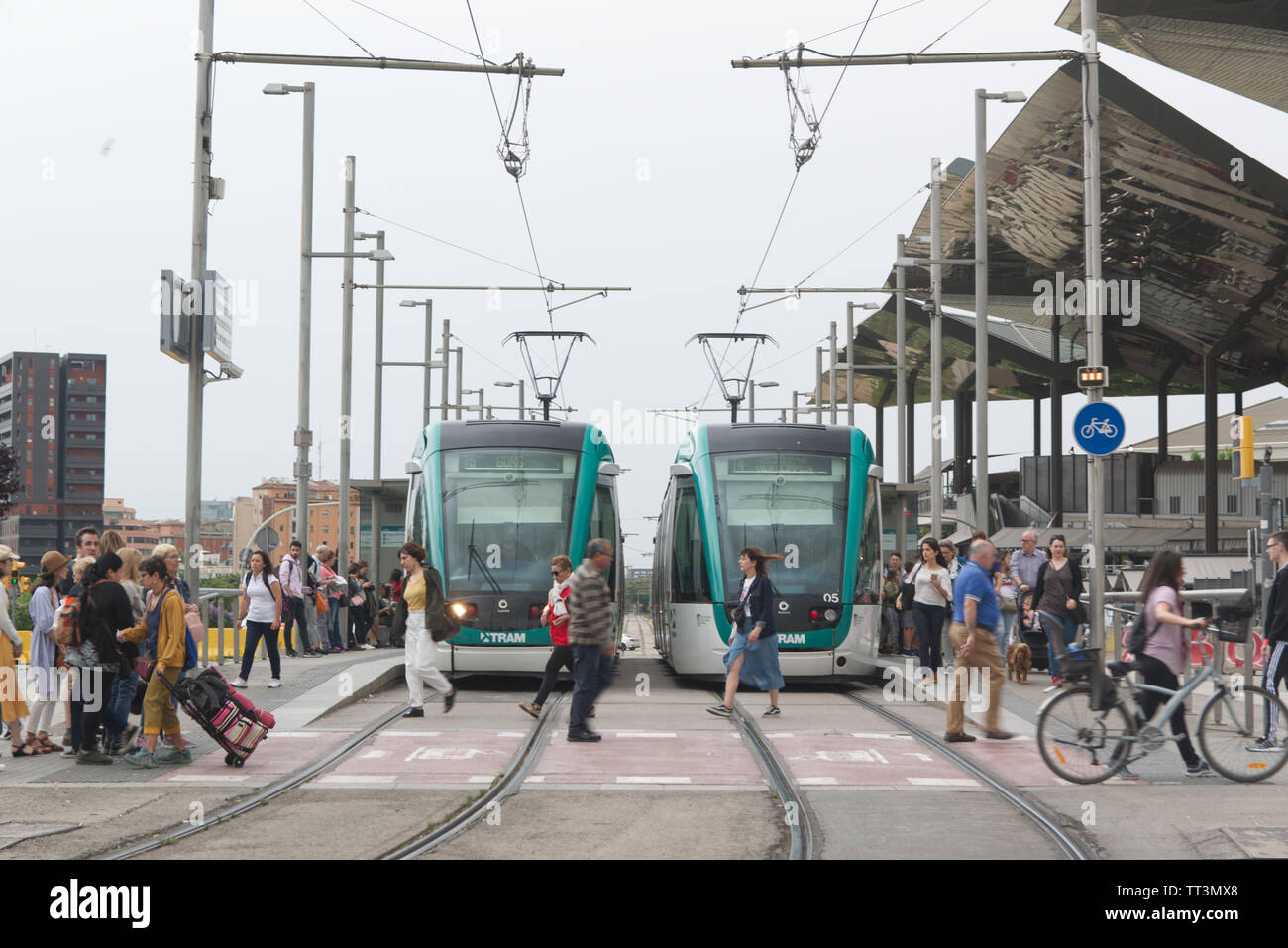 Barcellona Giugno 14, 2019: due treni tram sulle rotaie e una folla accanto alla stazione del tram a Barcellona Foto Stock