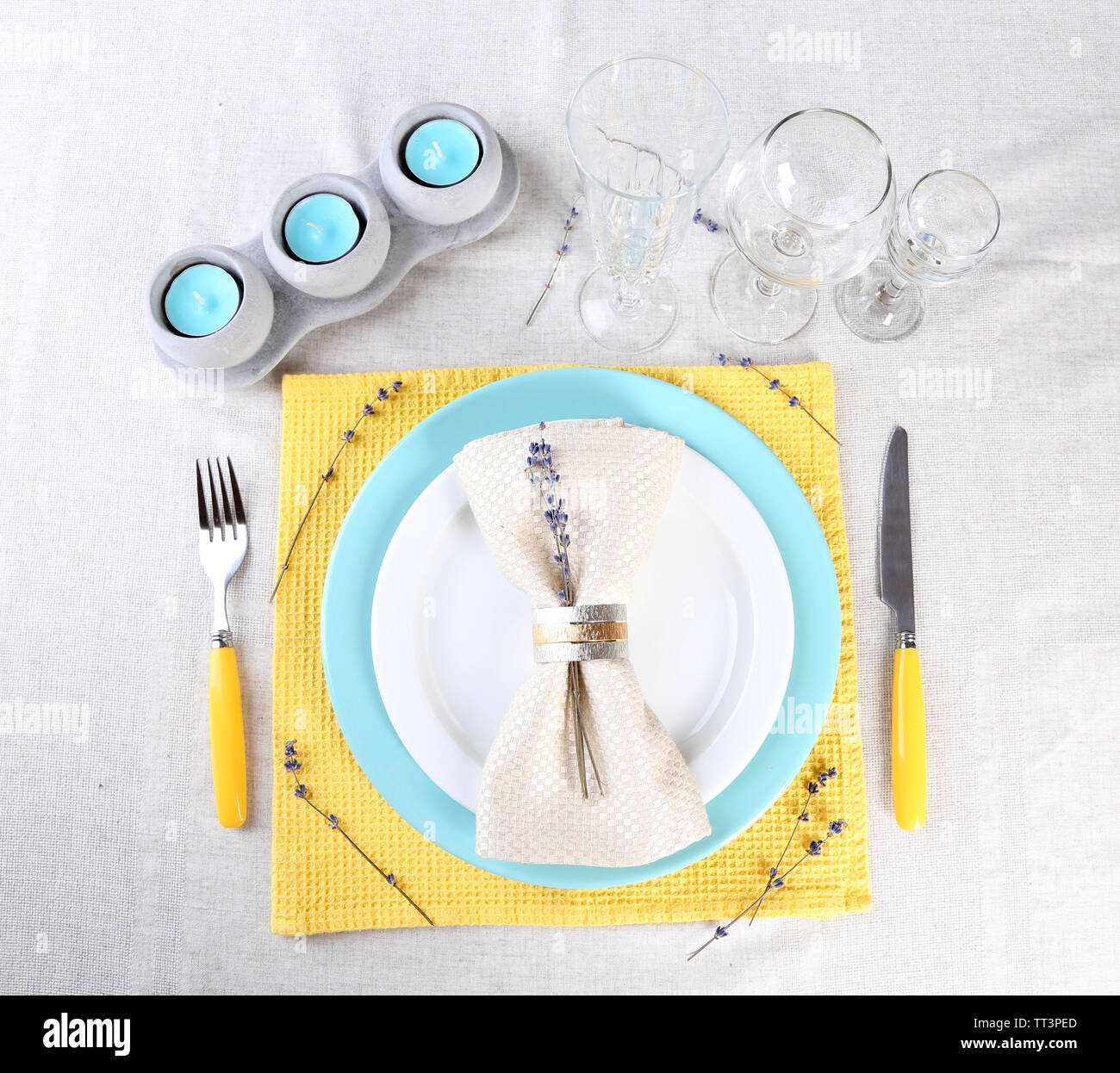 Tavolo da pranzo impostazione con fiori di lavanda sulla tovaglia di luce sullo sfondo Foto Stock