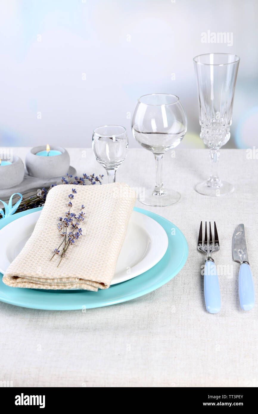 Tavolo da pranzo impostazione con fiori di lavanda su tavola, su sfondo chiaro Foto Stock