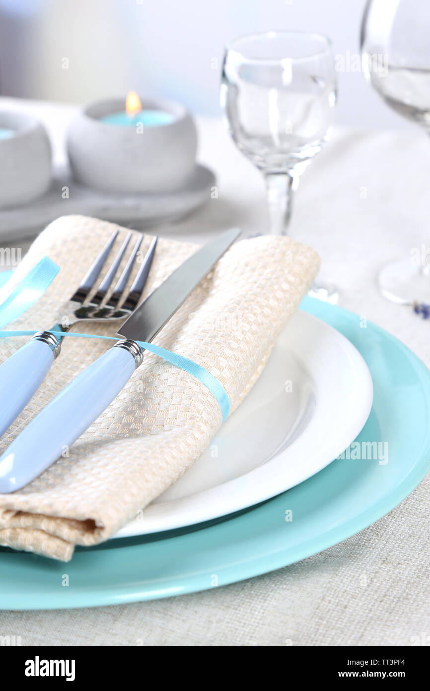 Tavolo da pranzo impostazione con fiori di lavanda sulla tovaglia di luce sullo sfondo Foto Stock
