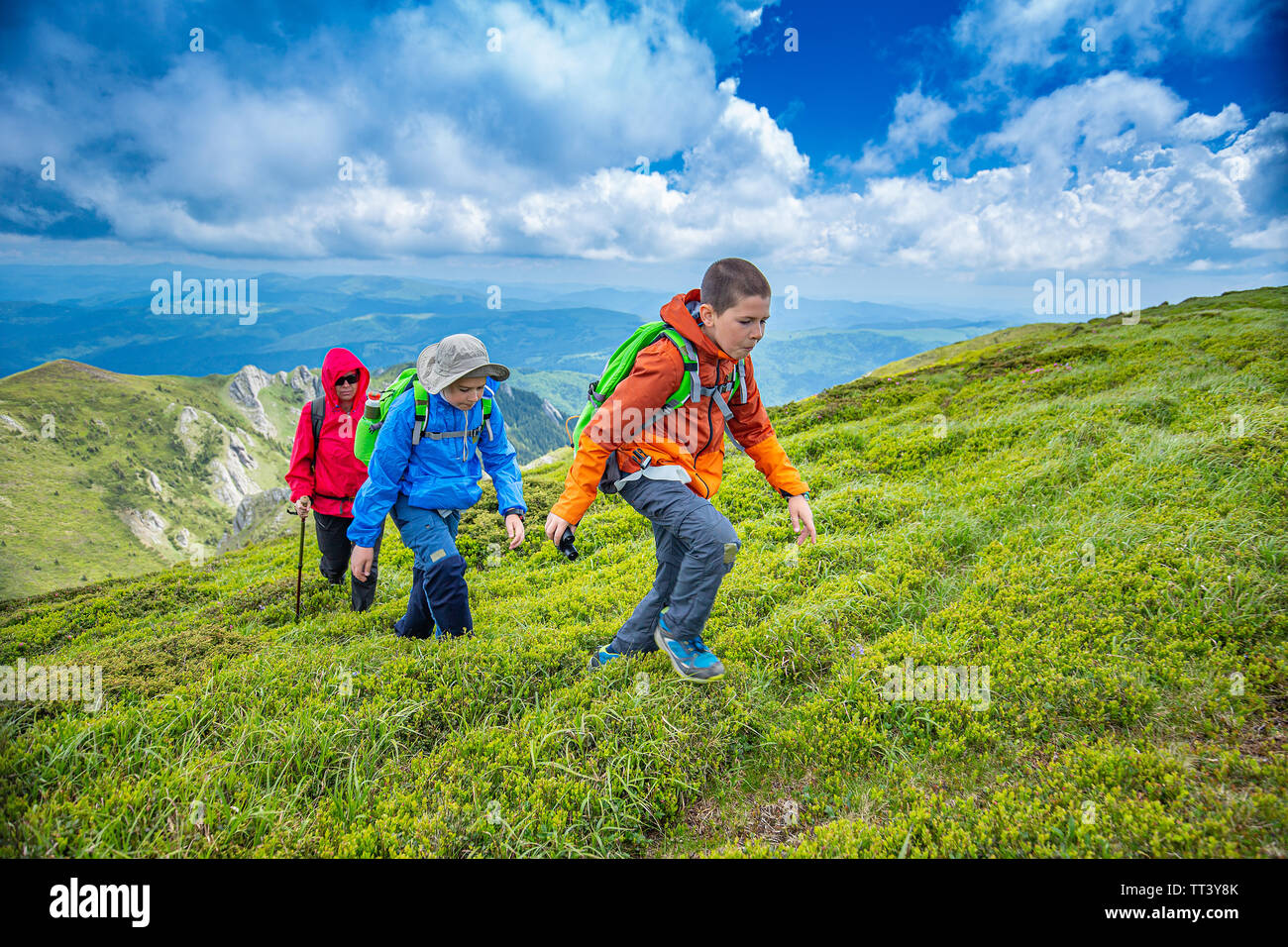 I due ragazzi sono escursioni con la loro madre sulla montagna Foto Stock