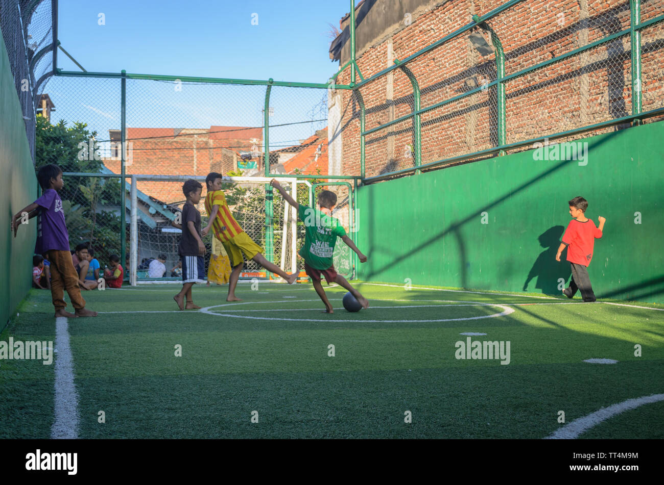 Bambini indonesiani a giocare a calcio nel parco, Surabaya, East Java, Indonesia Foto Stock