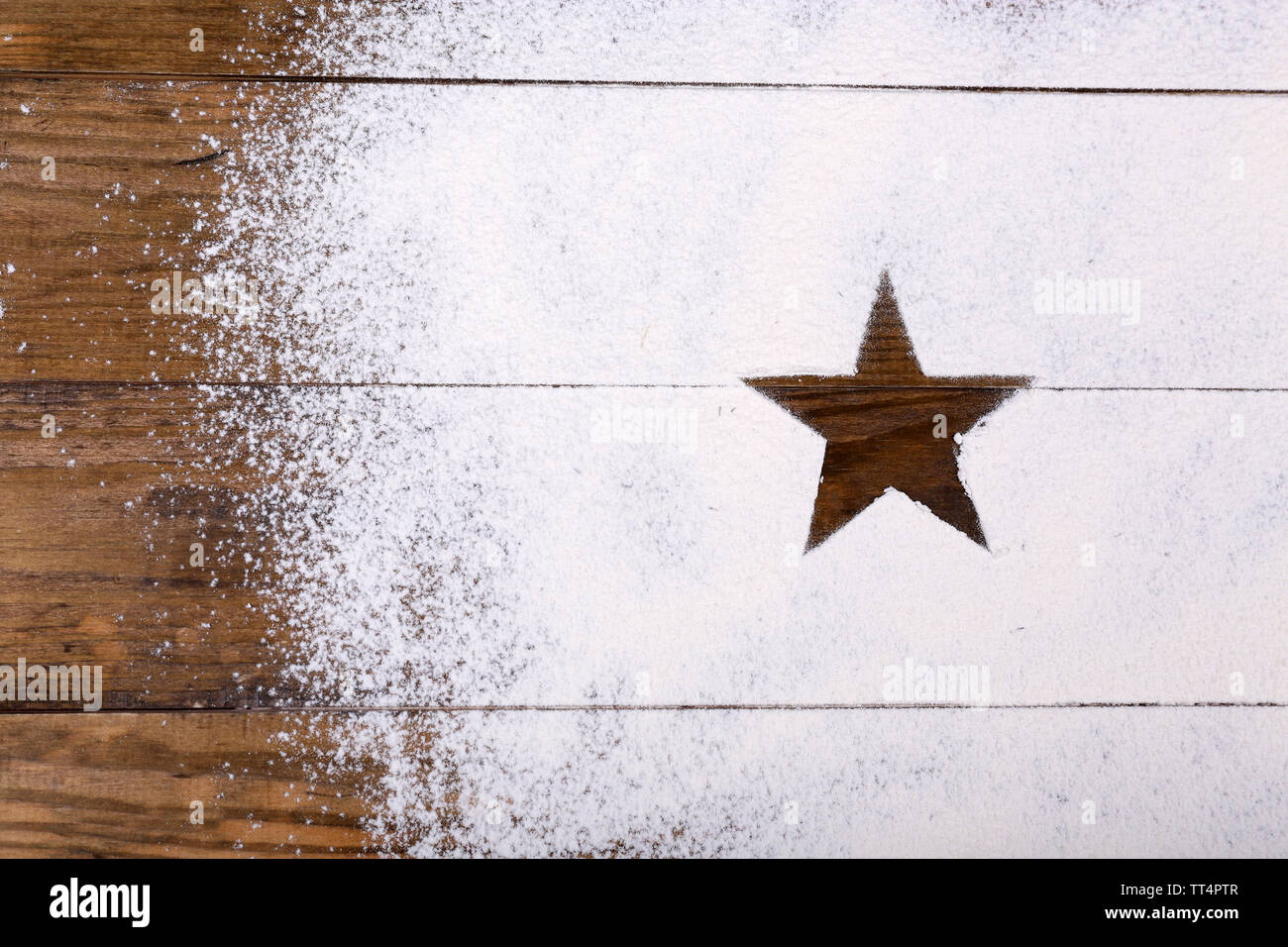 Star figura fatta di zucchero in polvere su sfondo di legno Foto Stock
