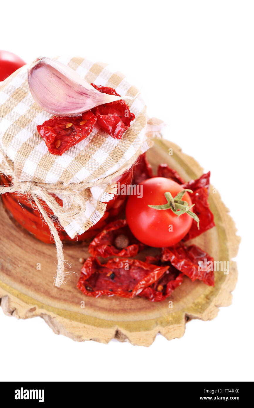 Pomodori secchi in un barattolo di vetro e le foglie di basilico isolato su bianco Foto Stock