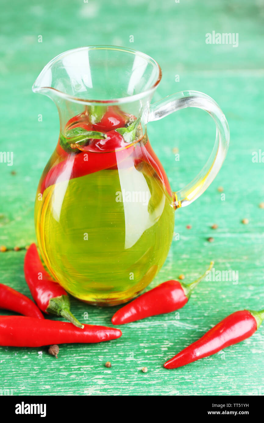 Prodotti naturali fatti in casa infuso di olio di oliva con peperoncino rosso il colore di sfondo di legno Foto Stock