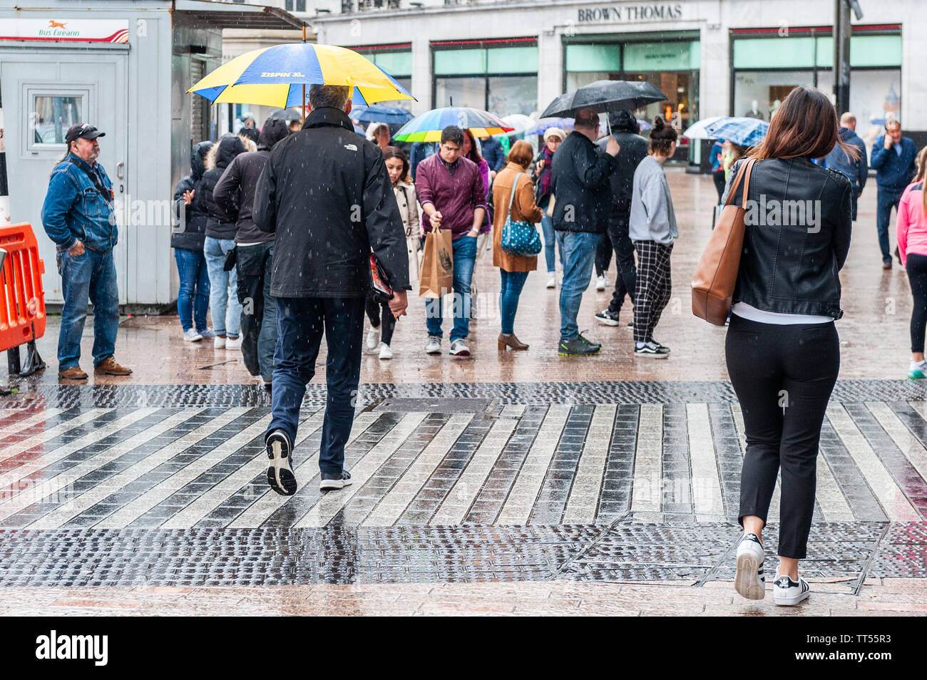 Cork, Irlanda. 14 Giugno, 2019. Shoppers rush per cercare di uscire da pioggia in un giorno di pioggia su Patrick Street, Cork City Centre. Credito: Andy Gibson/Alamy Live News. Foto Stock