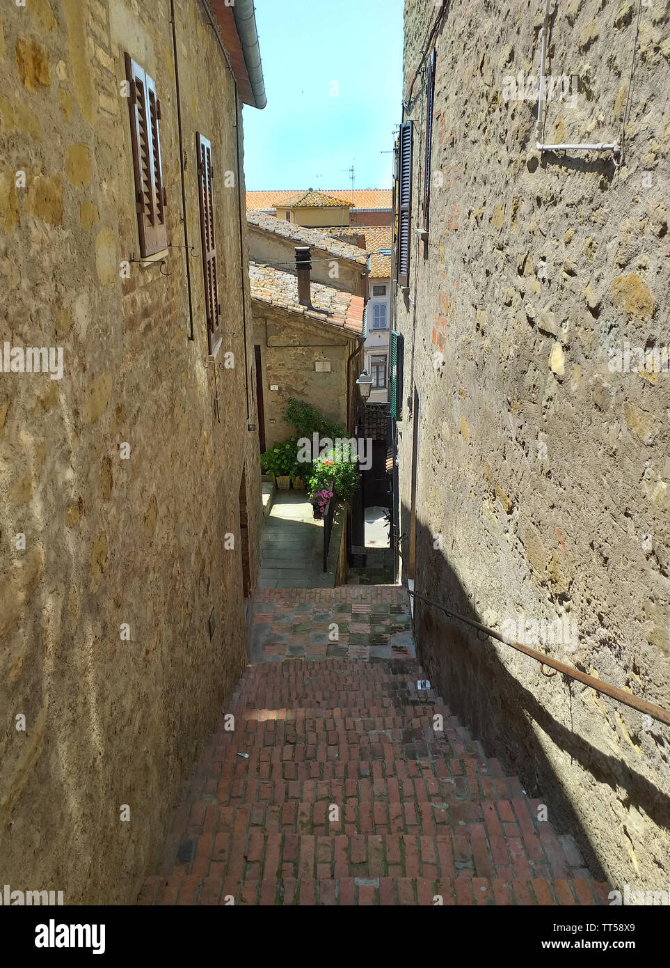 Una scala conduce in basso, strette delimitate da pareti di case residenziali. Tipica architettura italiana nel quartiere residenziale. Foto Stock