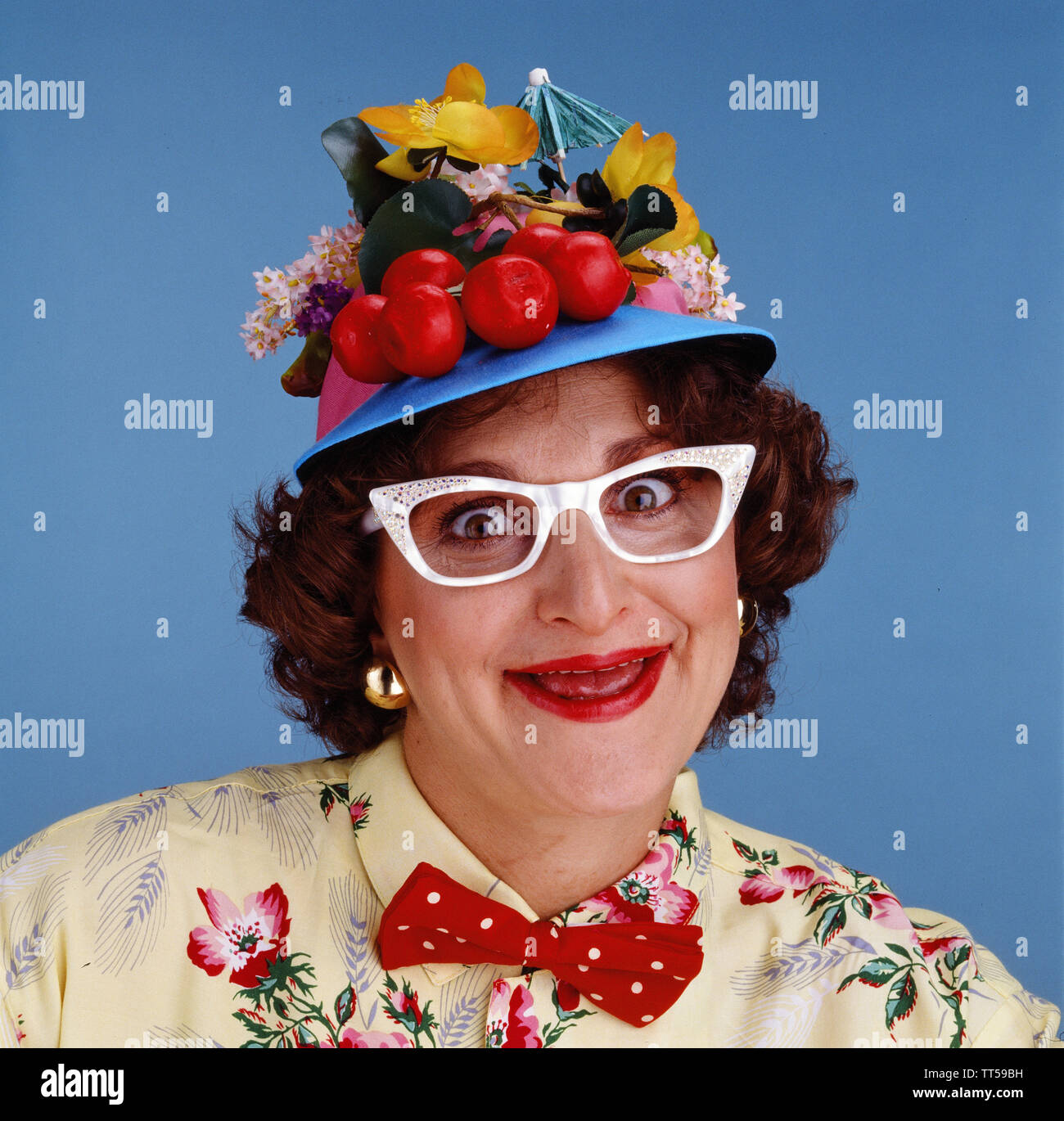 Crazy da stupidi donna che indossa un cappello fatto di frutta Foto Stock