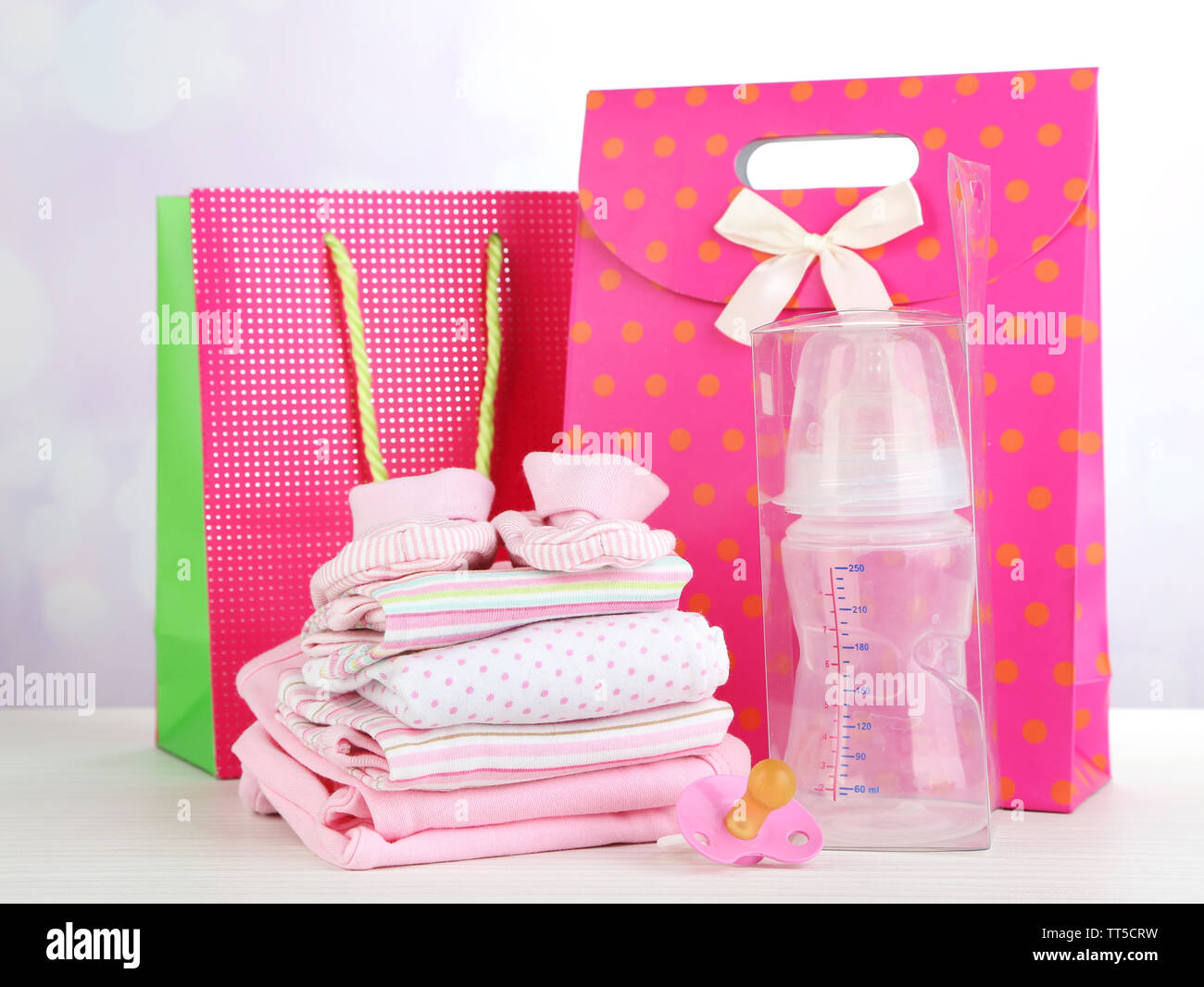 Vestiti del bambino e buste regalo su sfondo lucido Foto stock - Alamy