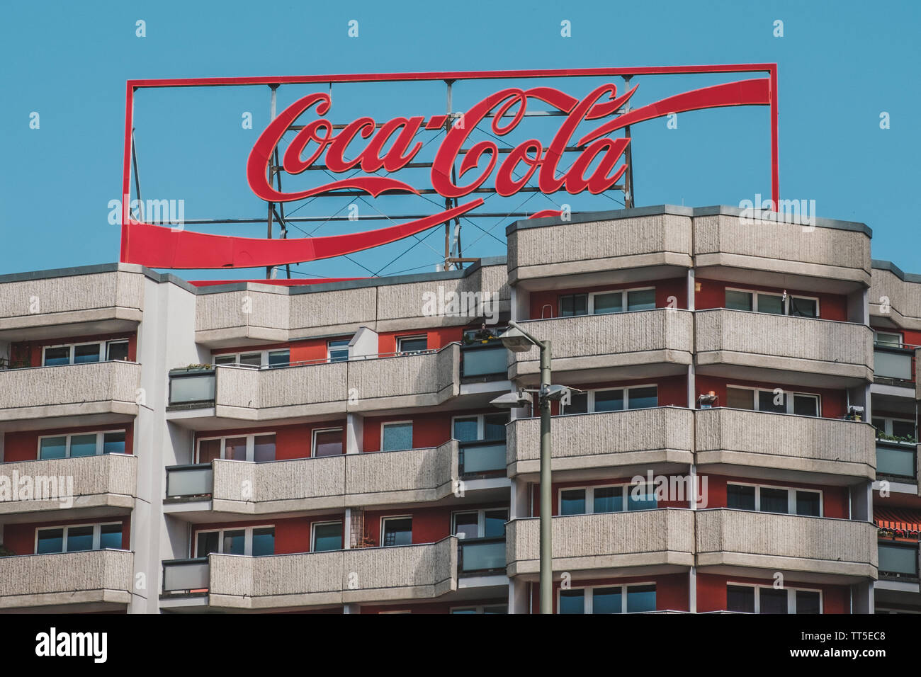 Berlino, Germania - Giugno 2019: Il logo della Coca Cola pubblicità luce al neon lettere sul tetto edificio a Berlino, Germania Foto Stock