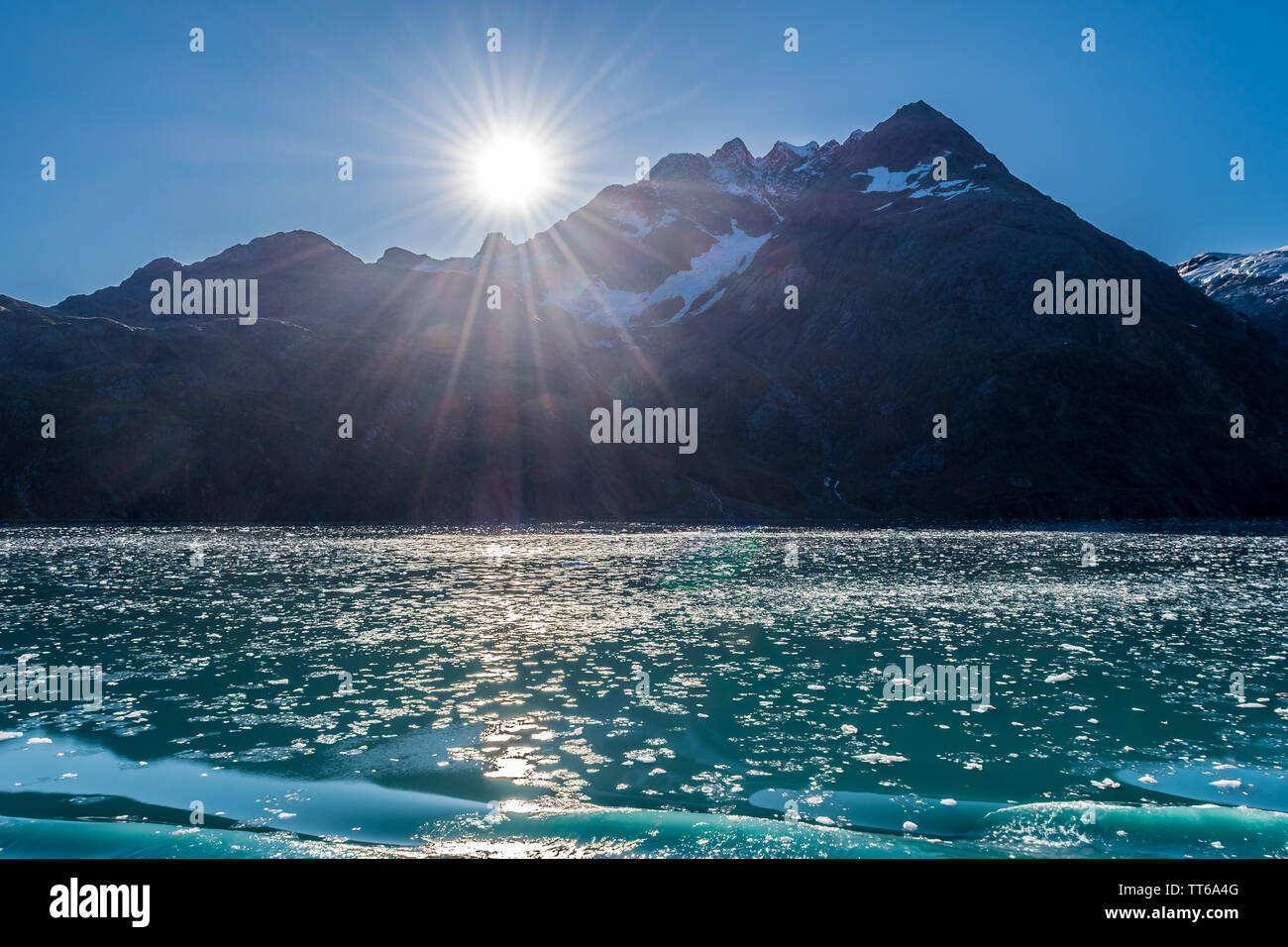 Rottura di pezzi di ghiaccio da ghiacciai galleggianti nel lago. Montagne innevate sullo sfondo in una giornata di sole. La nave di crociera tour nel Glacier Bay, Alaska Foto Stock