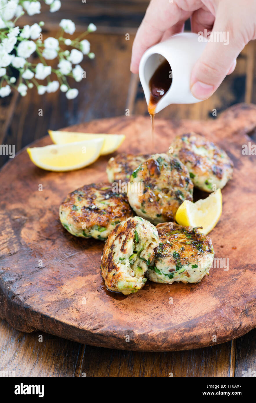 Fresche fritte polpette di pollame, Turchia, costolette di pollo sulla piastra su tavola di legno, salsa di colata Foto Stock