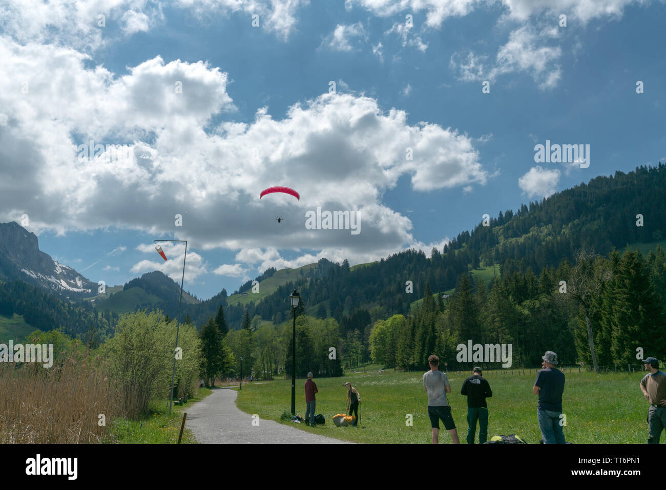 Schwarzsee FR / Svizzera - 1 Giugno 2019: istruttori e studenti lavorano insieme durante un corso di formazione per il parapendio nelle Alpi svizzere di Fribo Foto Stock