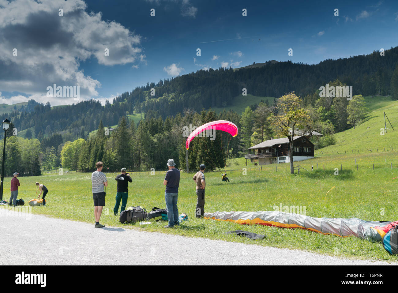 Schwarzsee FR / Svizzera - 1 Giugno 2019: istruttori e studenti lavorano insieme durante un corso di formazione per il parapendio nelle Alpi svizzere di Fribo Foto Stock