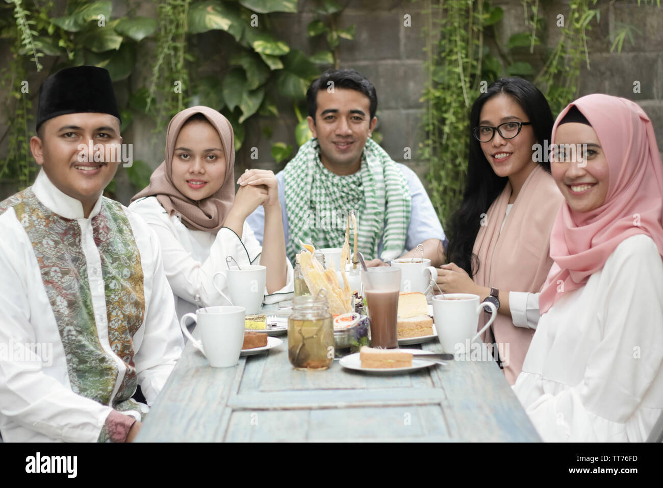 Gruppo di felice giovani musulmani di consumare la cena all'aperto durante il ramadan celebrazione, rompere il digiuno Foto Stock