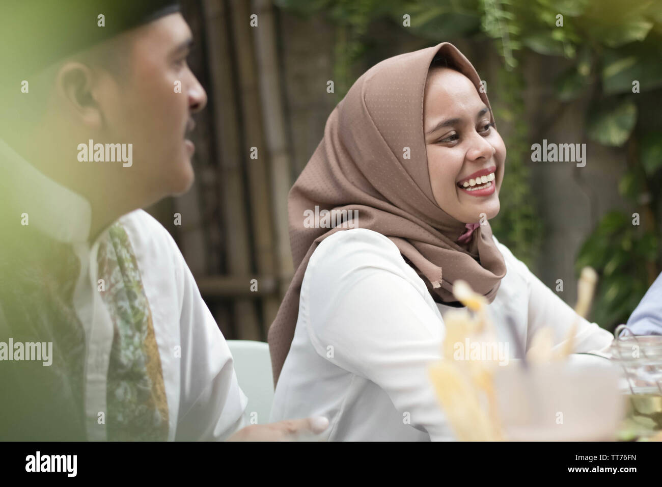 Giovane e belle donne asiatiche sorridere mentre a pranzo con gli amici durante il ramadan celebrazione, rompere il digiuno Foto Stock