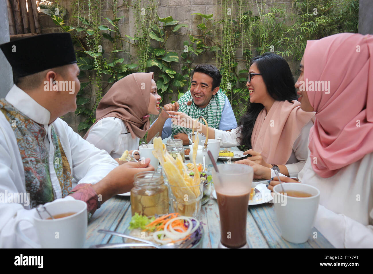 Gruppo di felice giovani musulmani di consumare la cena all'aperto durante la celebrazione del ramadan Foto Stock
