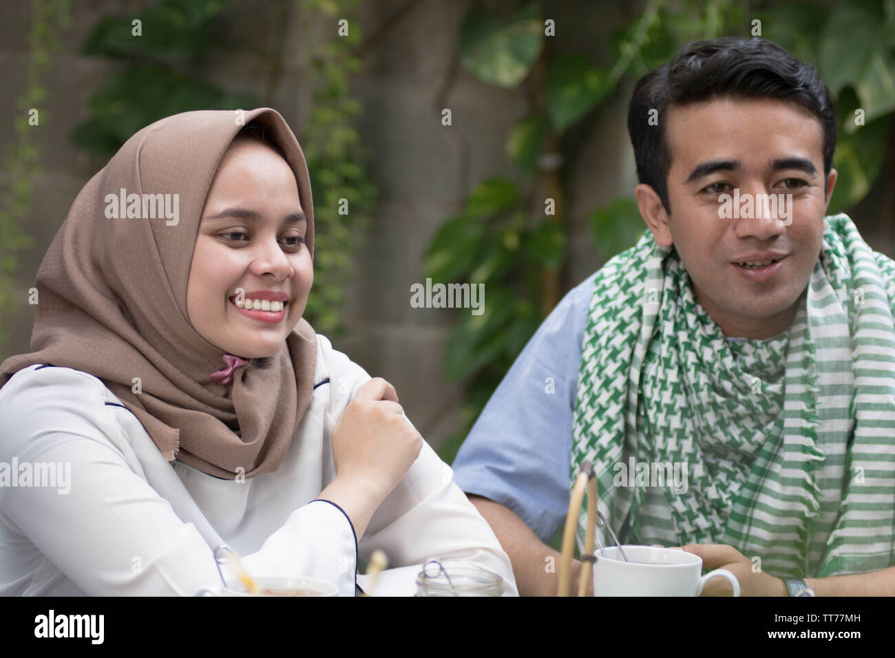 Coppia giovane musulmano avente la conversazione in midle di pranzo Foto Stock