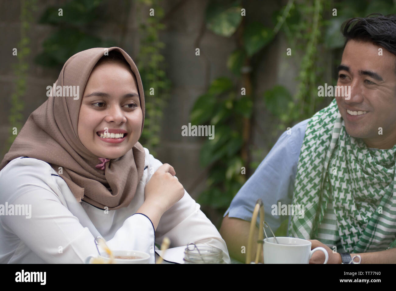 Coppia giovane musulmano avente la conversazione in midle di pranzo Foto Stock