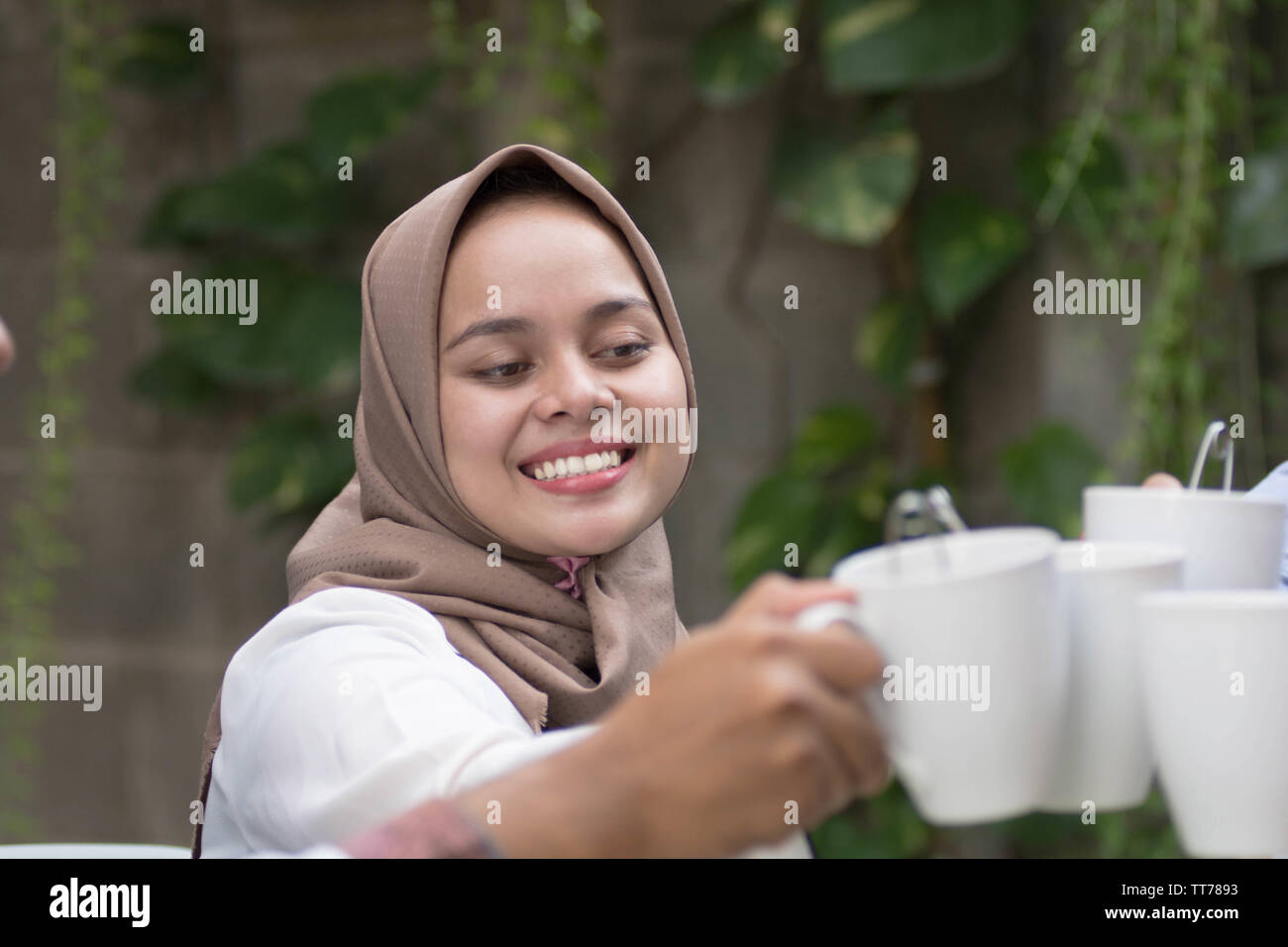 Il hijab donne aventi il tè toast a tavola ristoranti durante la celebrazione del ramadan Foto Stock