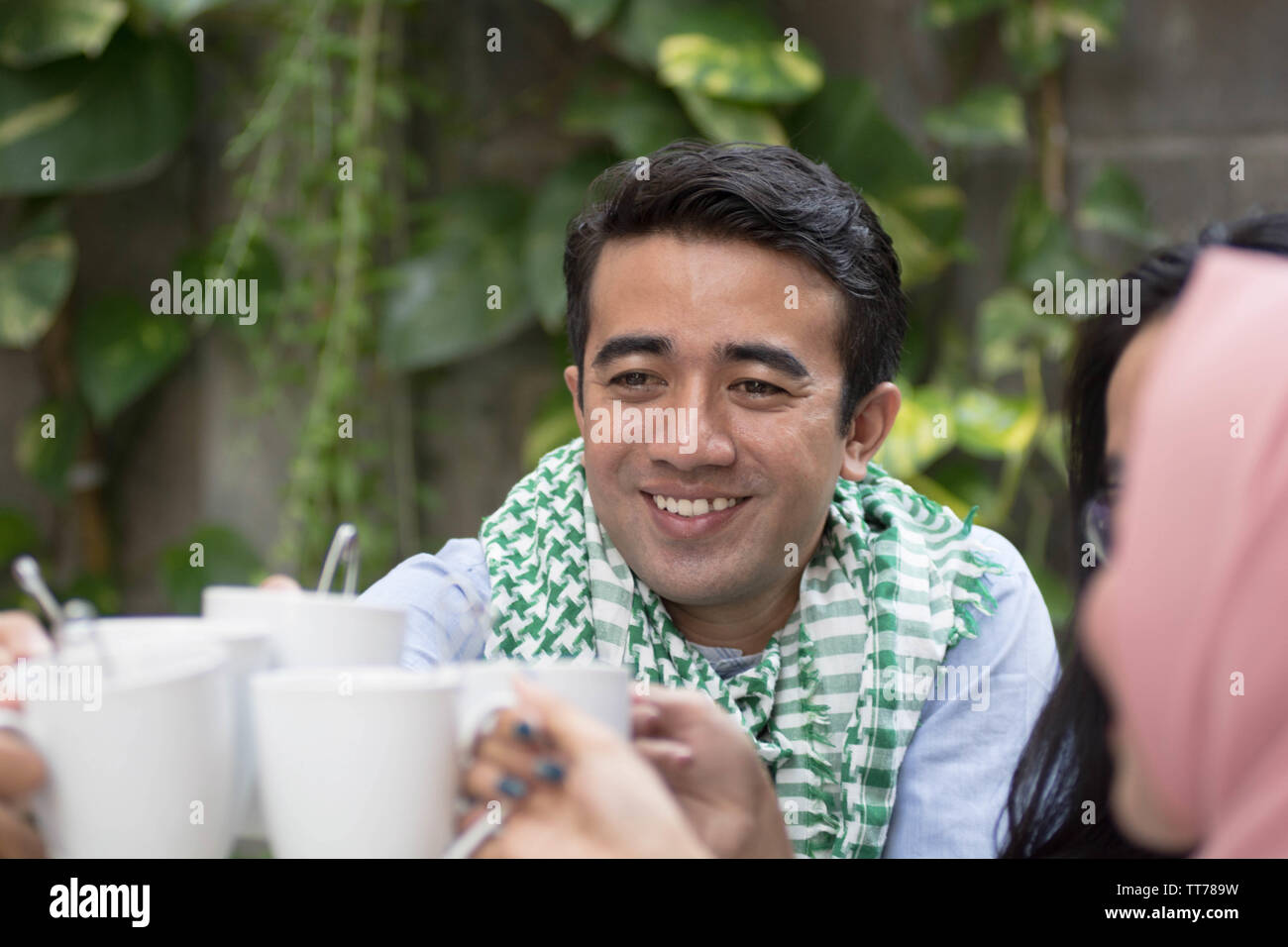 Uomo bello con sciarpa avente il tè toast a tavola ristoranti durante il ramadan celebrazione durante il ramadan celebrazione, rompere il digiuno Foto Stock