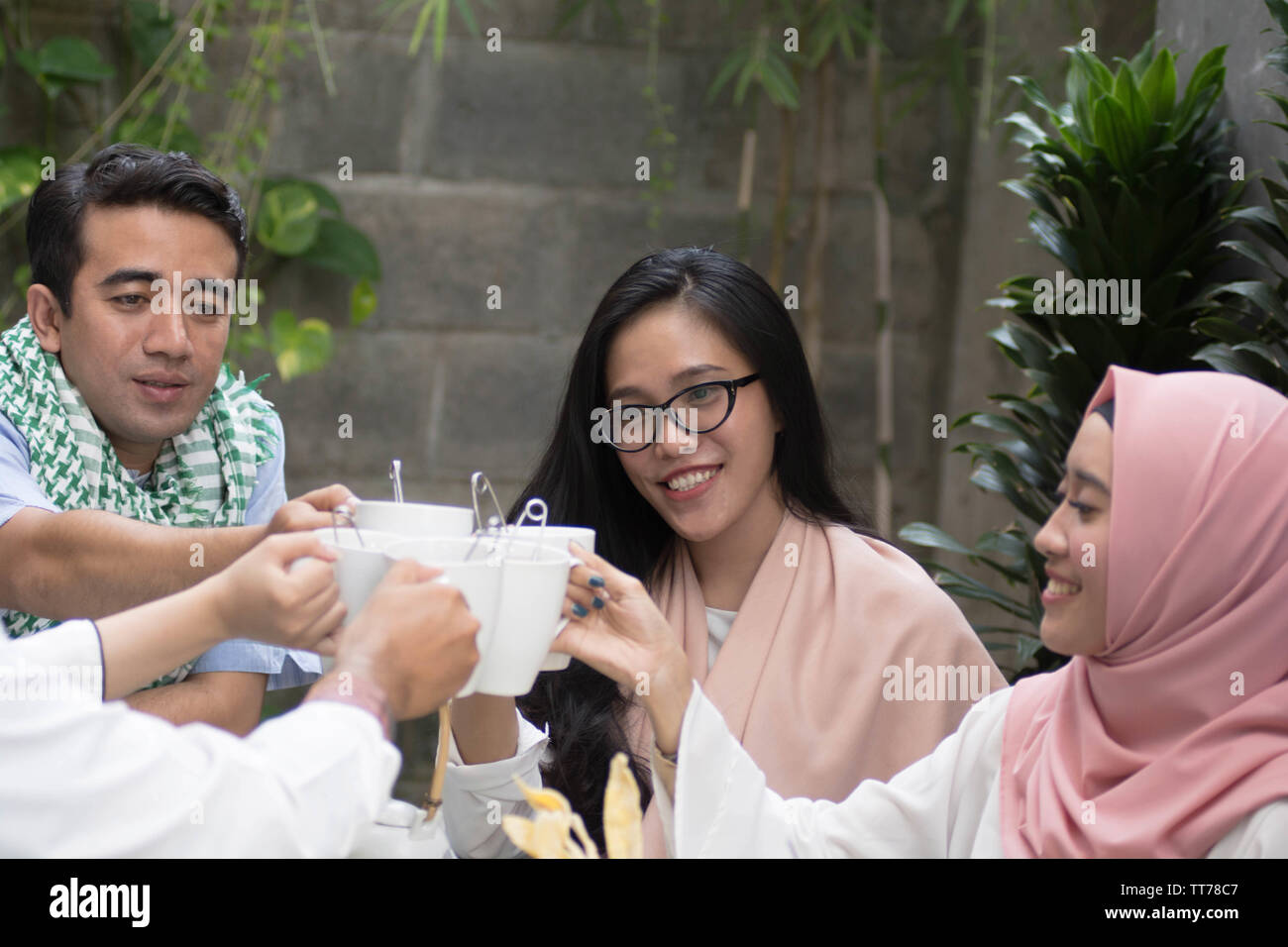 Gruppo di amici avente il tè toast a tavola ristoranti durante la celebrazione del ramadan Foto Stock