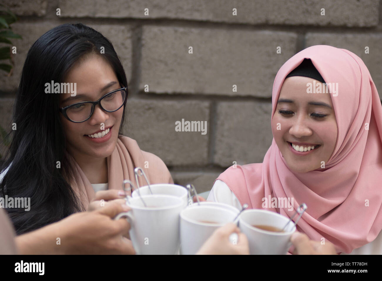 Gruppo di amici avente il tè toast a tavola ristoranti durante la celebrazione del ramadan Foto Stock