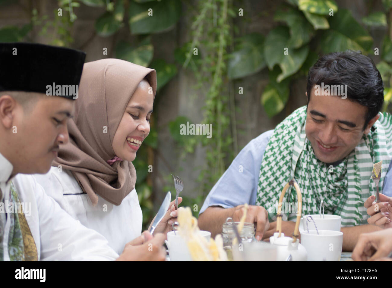 Gruppo di felice giovani musulmani di consumare la cena all'aperto durante la celebrazione del ramadan Foto Stock