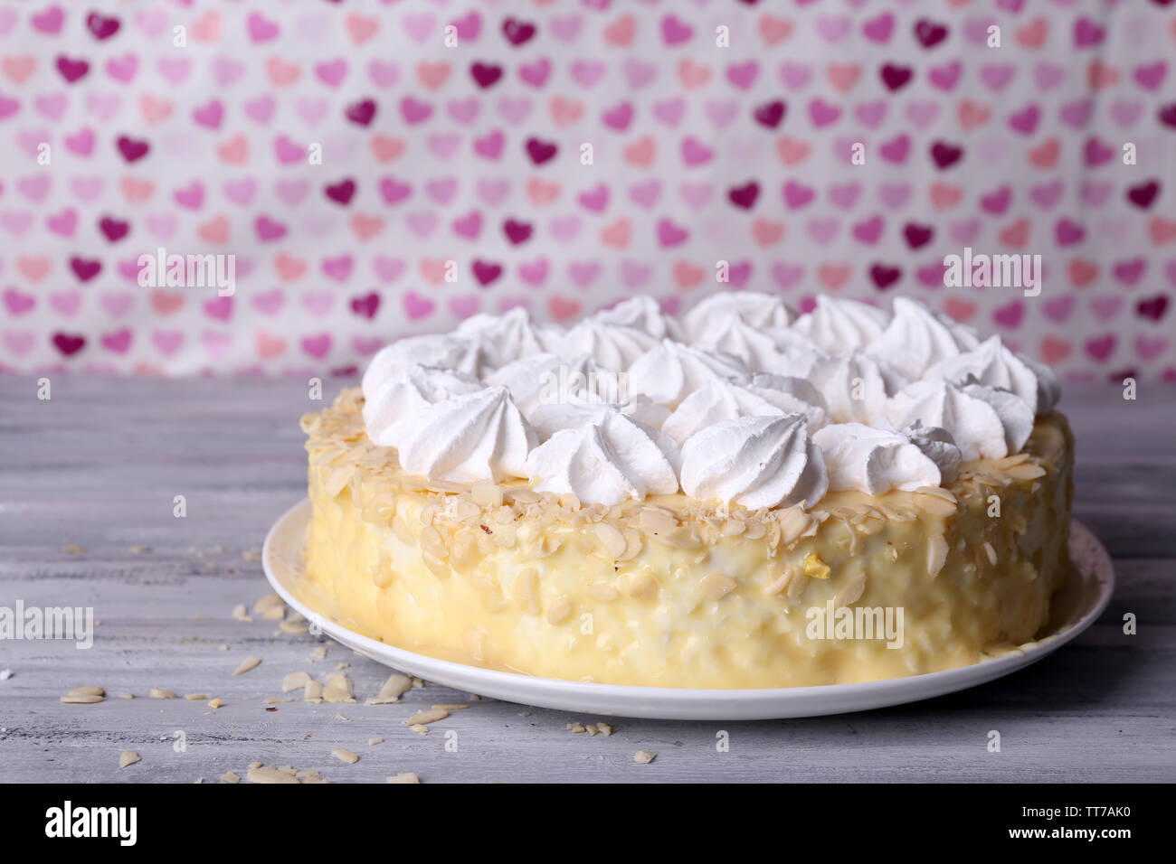 Gustosi piatti fatti in casa torta di meringa su un tavolo di legno, su sfondo rosa Foto Stock