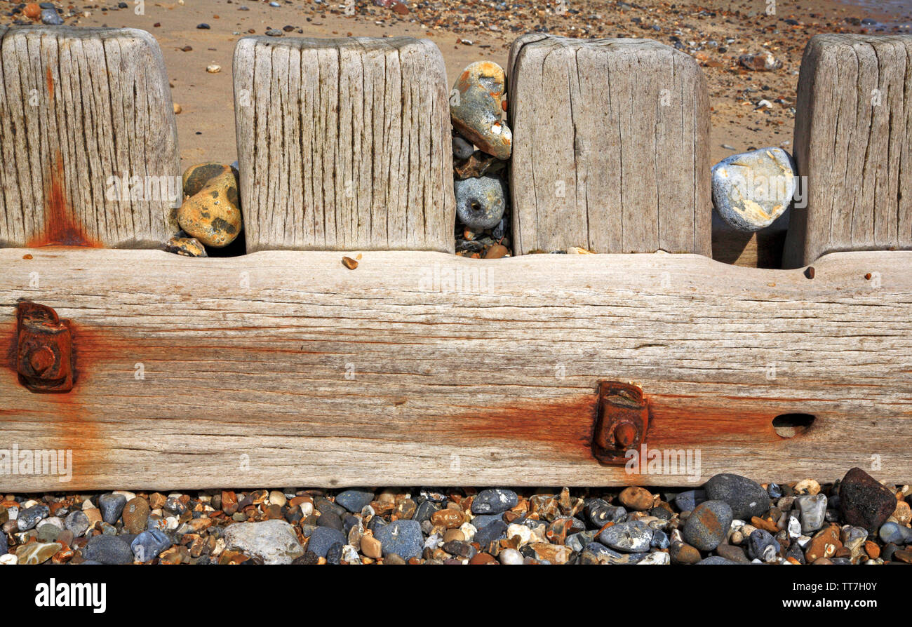 Pietre incuneato in una scogliera di legname sulla costa est a carrello Gap, Happisburgh, Norfolk, Inghilterra, Regno Unito, Europa. Foto Stock