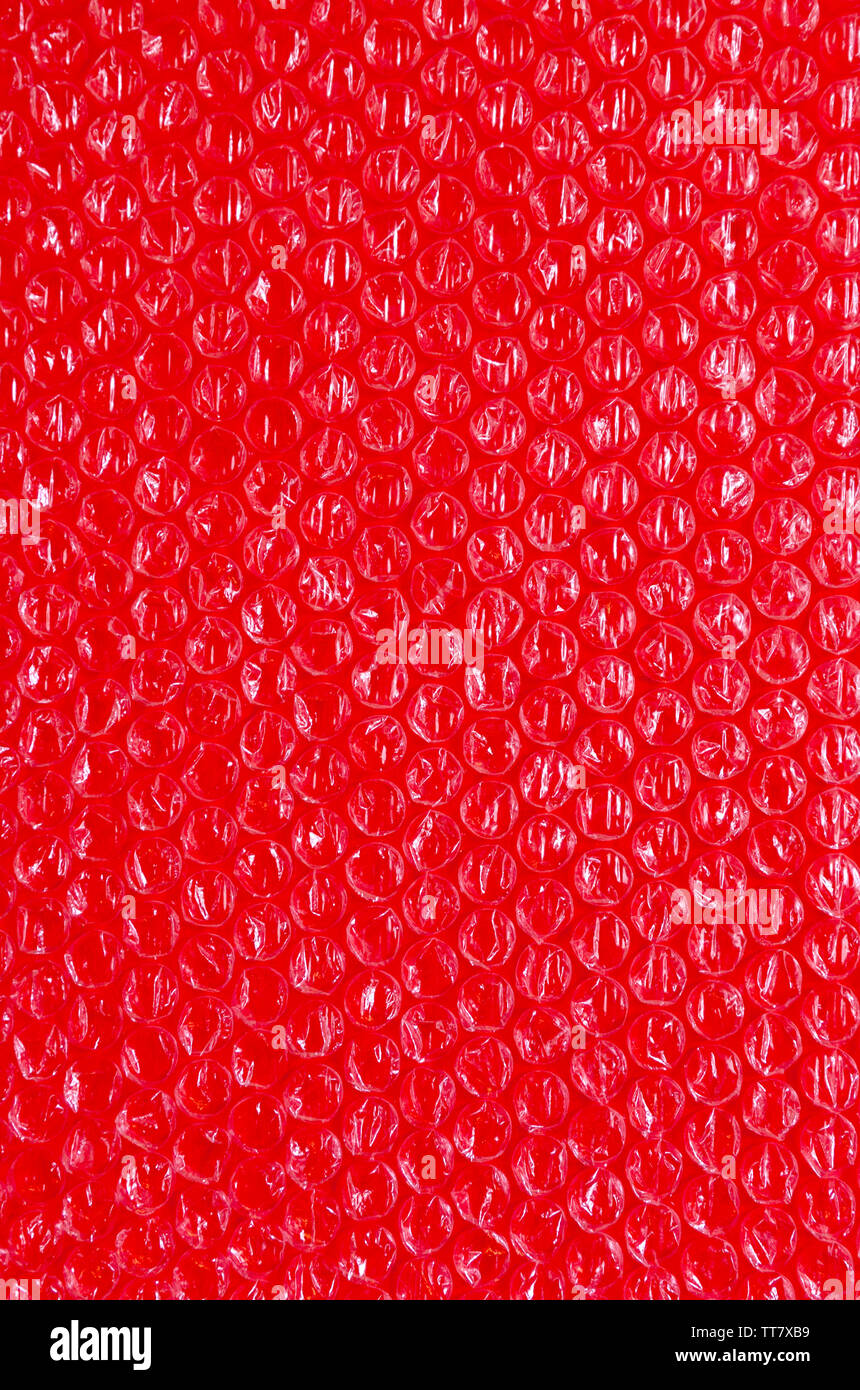 Cellophane e lo sfondo di plastica. La texture della vecchia plastica di imballaggio con sfere. L'immagine di colore rosso e bianco toni. Foto Stock