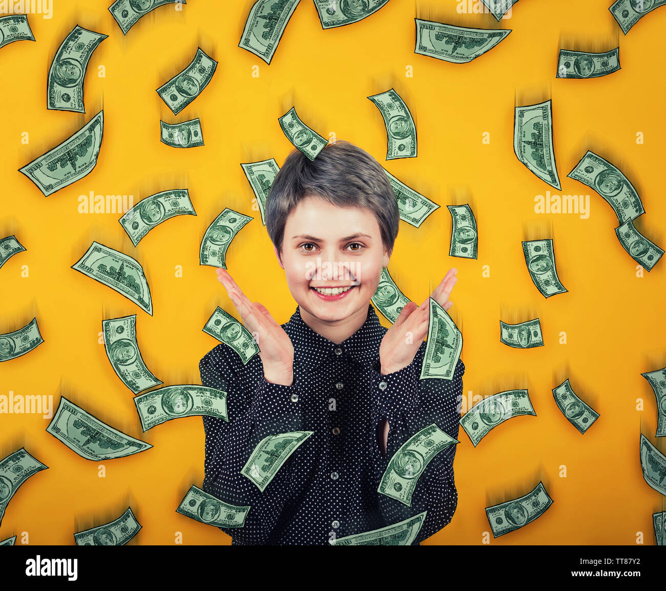 Ragazza emotiva sorrisi ampiamente, si diffonde le mani o di applausi contentissimo, esclama la felicità come il denaro sono la caduta del dollaro come pioggia dal cielo. Lotteria winni Foto Stock