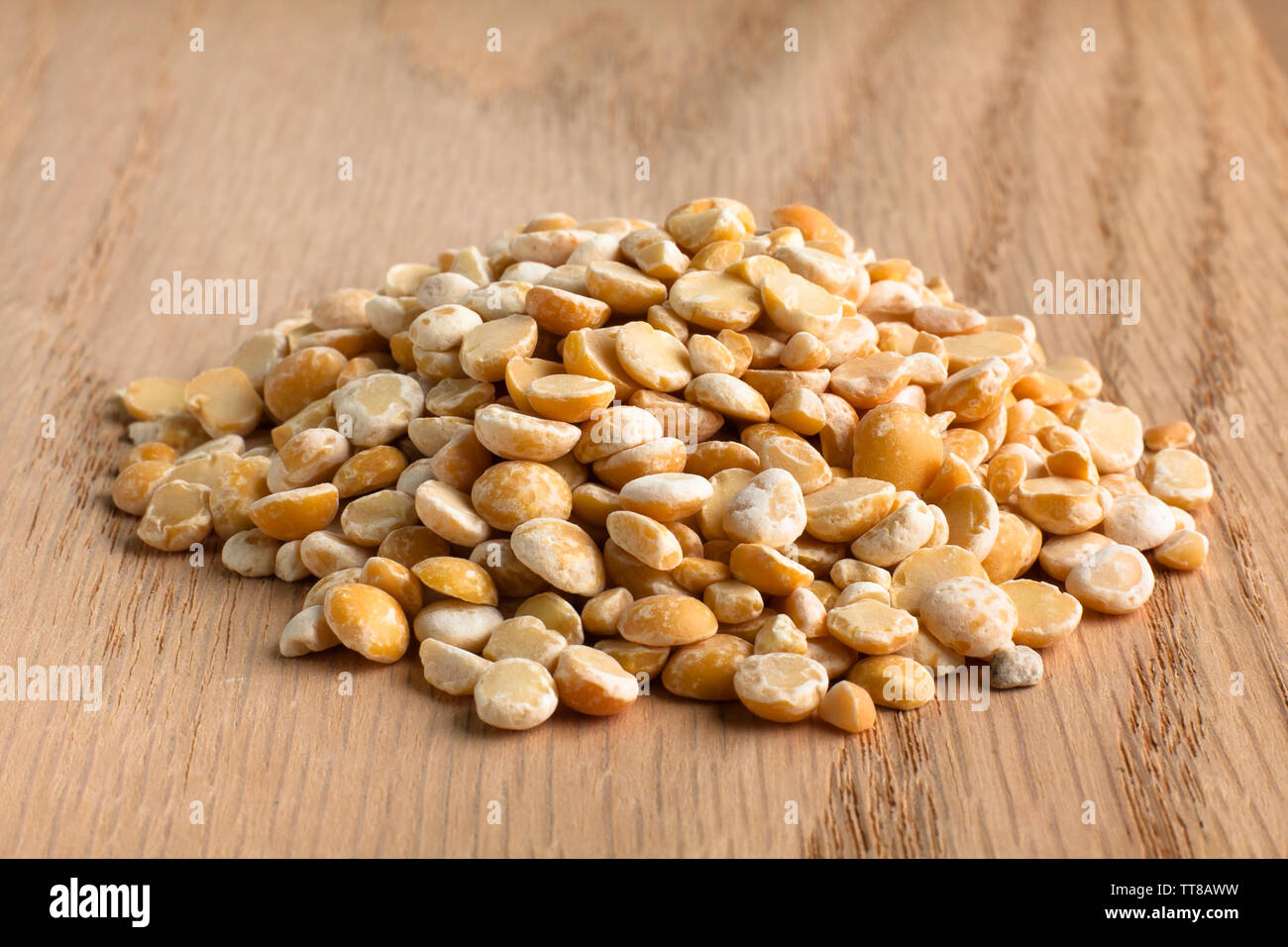 Cumulo di secco giallo piselli spezzati su sfondo di legno Foto Stock