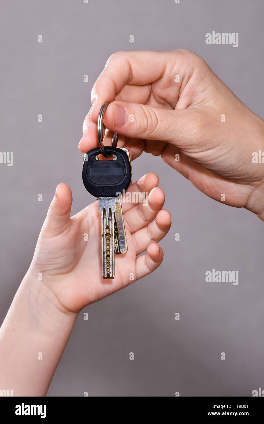 La mano di un adulto appendere le chiavi di casa per bambino Foto Stock