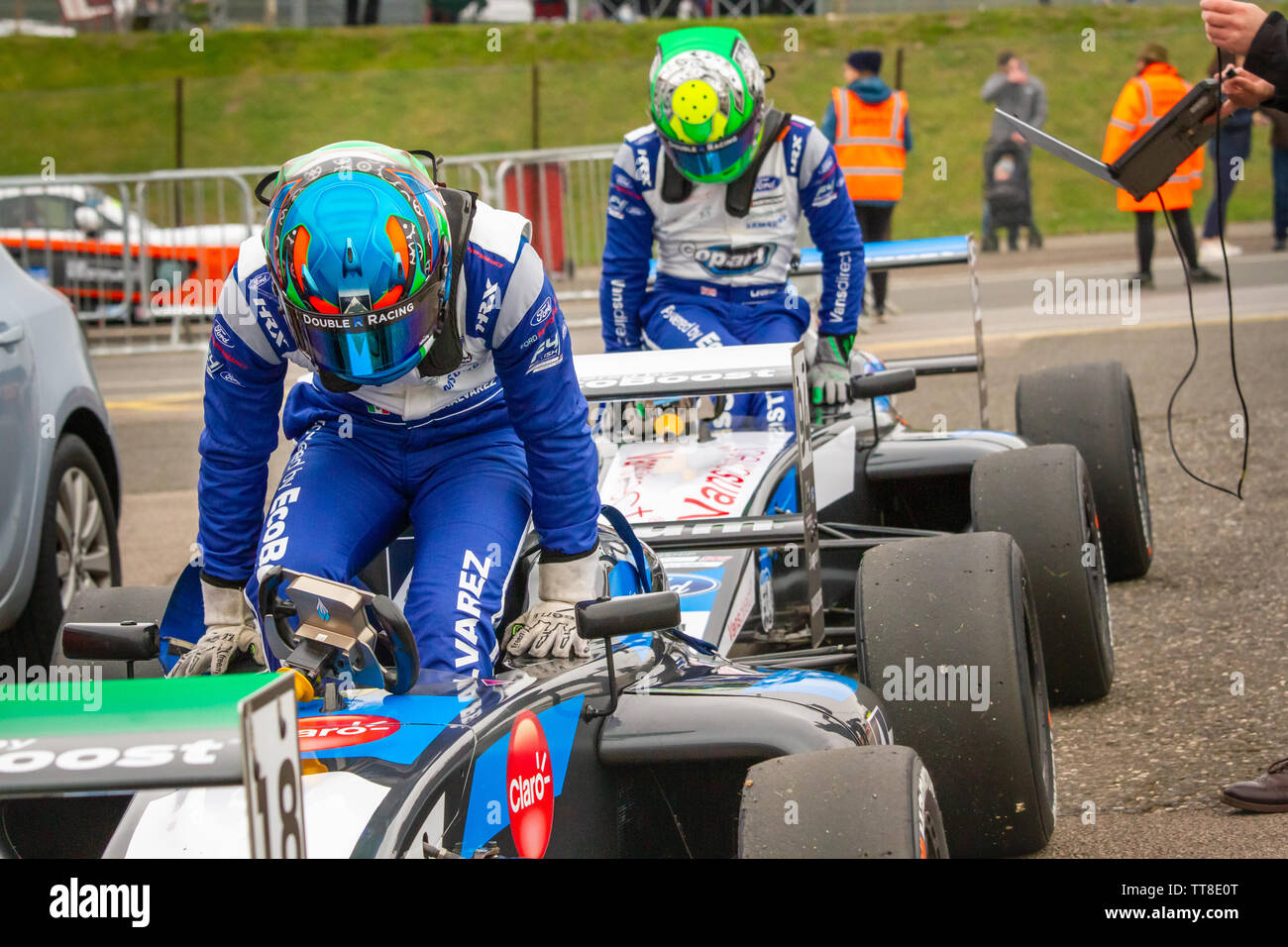 2 racing drivers salire dal loro vetture. British Formula 4 paddock, dopo le qualifiche a Brands Hatch Foto Stock