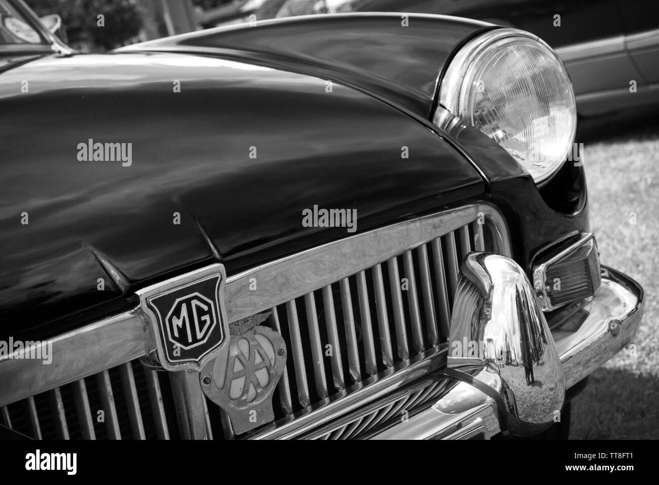 Parte anteriore sinistra di un classico vintage MG auto sportiva che mostra il badge, griglia del radiatore, il faro e il paraurti cromato dettaglio eseguita in bianco e nero. Foto Stock