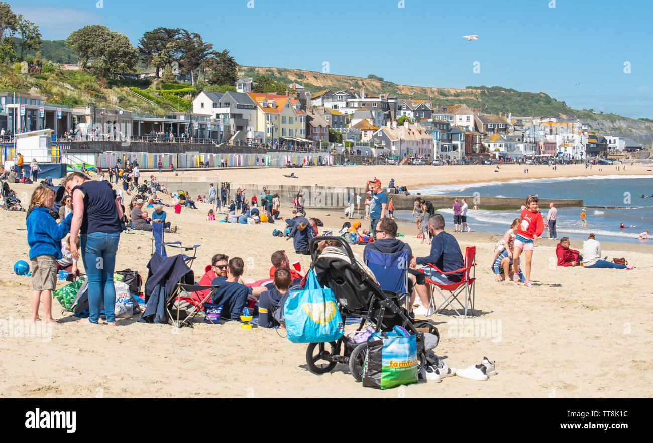 Lyme Regis, Dorset, Regno Unito. Il 15 giugno, 2019. Meteo REGNO UNITO: folle di musicisti e i visitatori accorrono alla spiaggia godetevi un pomeriggio di musica come le chitarre annuale sulla spiaggia evento si aprirà sulla spiaggia a Lyme Regis su un glorioso pomeriggio di sole caldo e luminoso blu del cielo. La folla è la star dello spettacolo come chitarristi di tutte le età e capacità di raccogliere insieme sulla spiaggia di eseguire insieme come "la Gran Bretagna più grande band". Le persone godono la rilassata atmosfera del festival prima di eseguire questo anno ha scelto il brano "sulla spiaggia". Credito: Celia McMahon/Alamy Live News Foto Stock