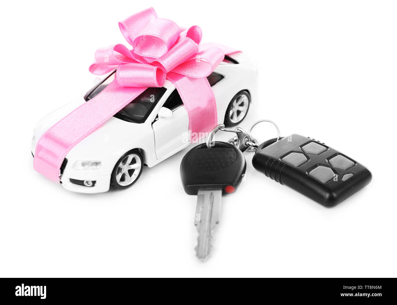 Chiavi e auto con fiocco rosa come presente isolato su bianco Foto Stock